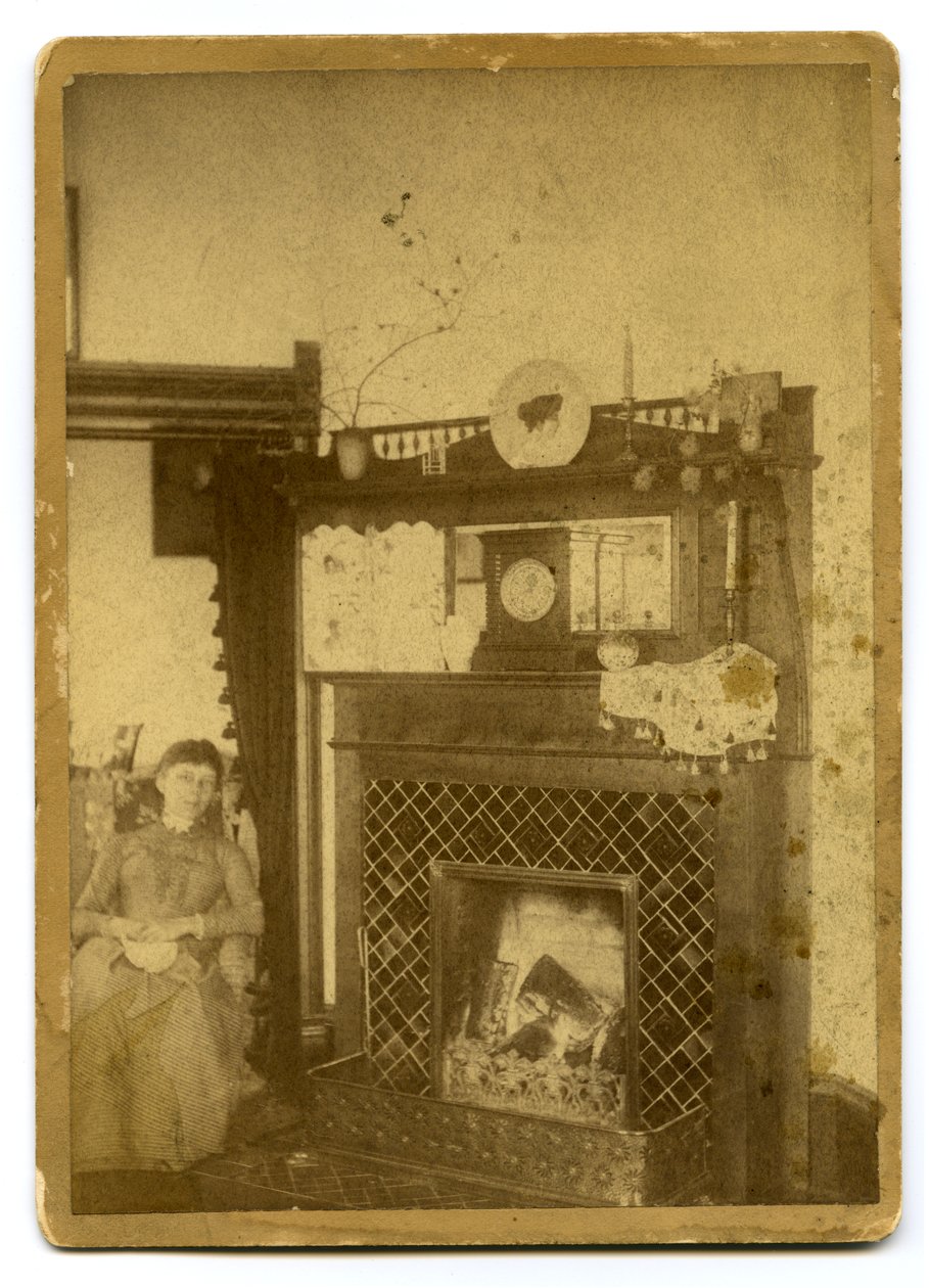 Mujer sentada junto a una chimenea encendida de Unknown