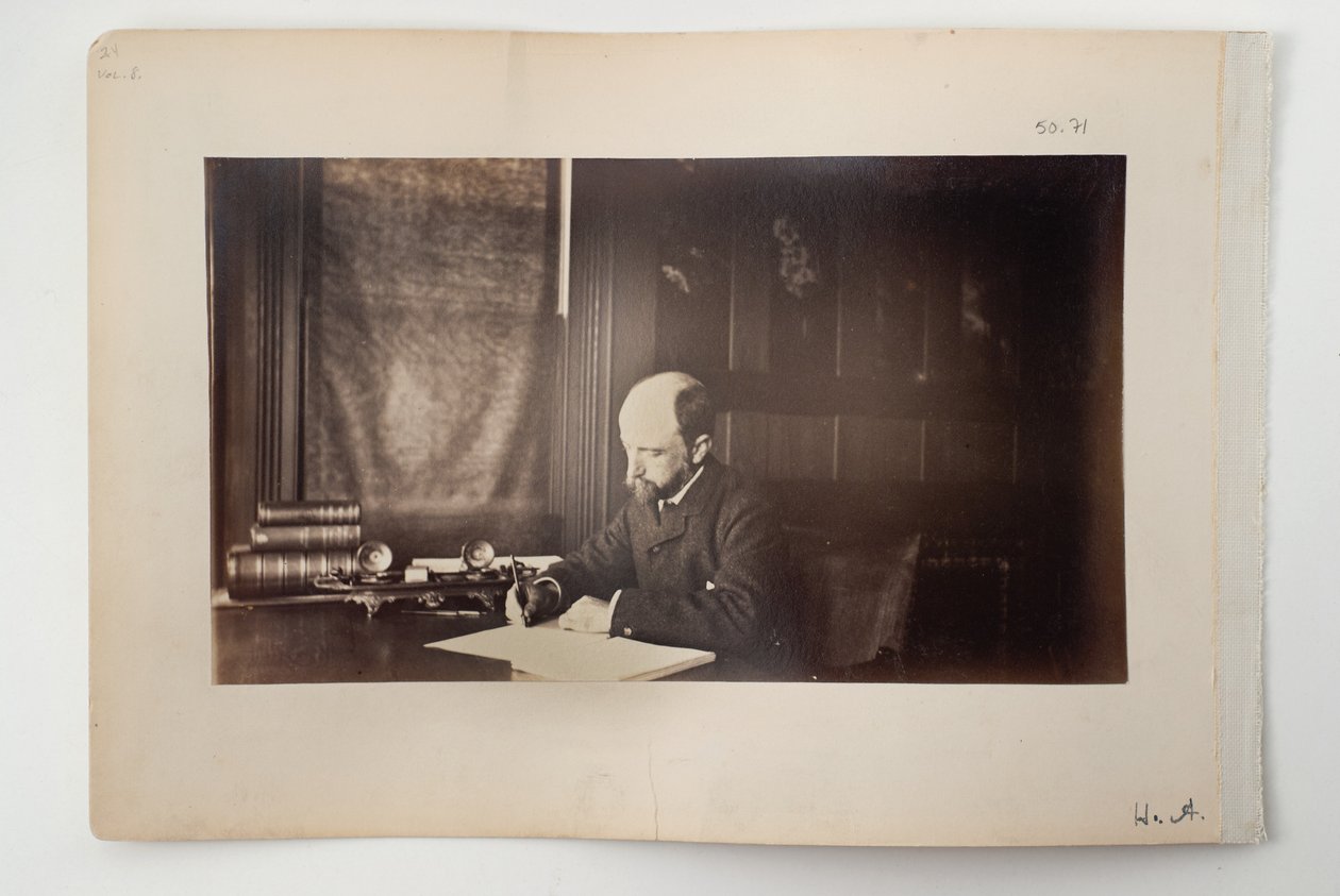 Henry Adams sentado en un escritorio de American Photographer
