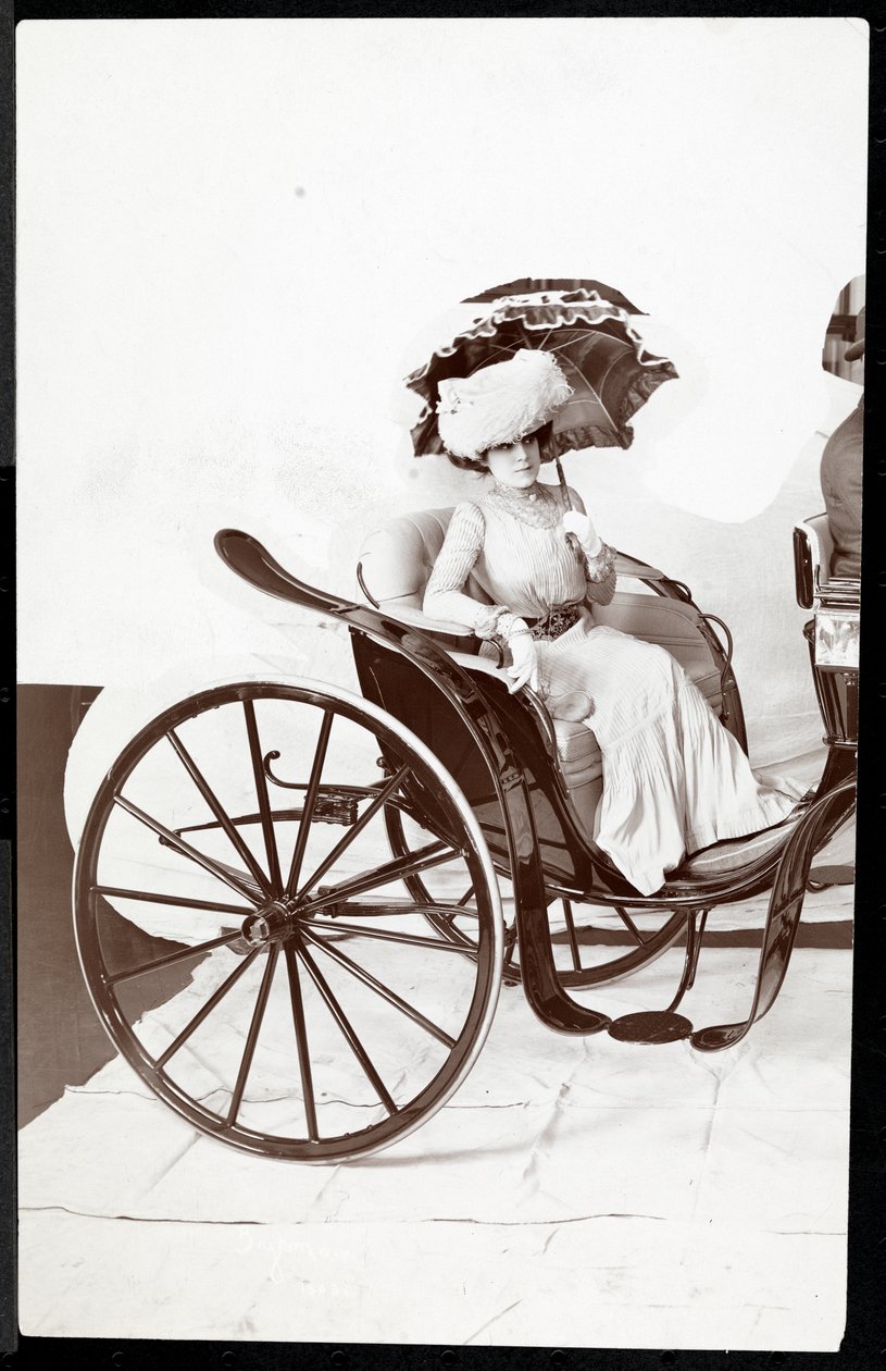 Una modelo de moda sentada en un carruaje sosteniendo una sombrilla, 1902 de Byron Company