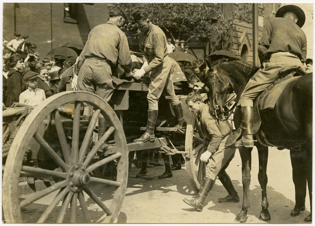 Fotografía horizontal en sepia que muestra a hombres uniformados descargando un objeto cubierto con la bandera estadounidense, posiblemente un ataúd, de un carro abierto. Una multitud de personas observa desde la acera de Carl Michel