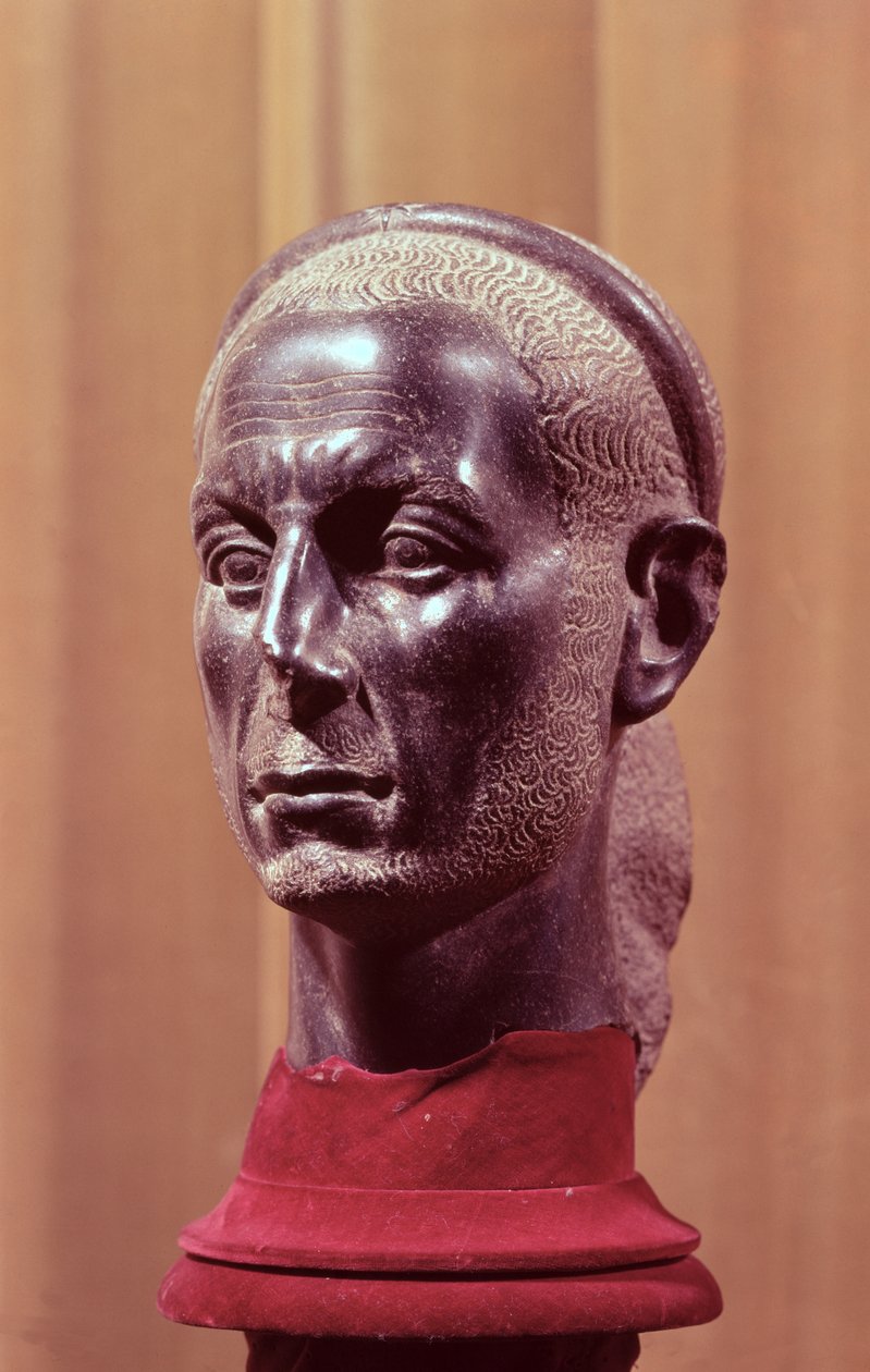 Cabeza de una estatua de un sacerdote barbudo con una diadema estrellada, se cree que es un busto retrato de Julio César (c.100-44 a.C.), Egipcio, del Delta del Nilo (diorita) de Egyptian School