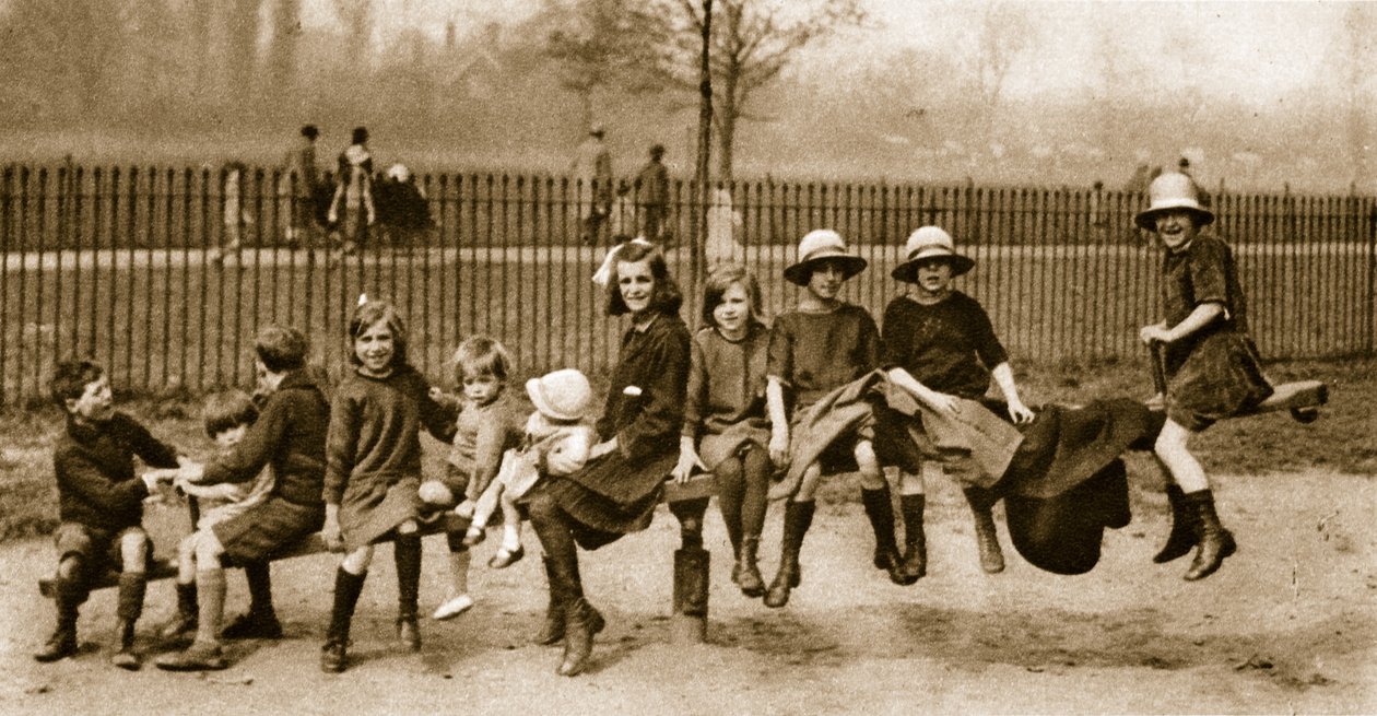 Niños jugando en un balancín en un parque de Londres de English Photographer