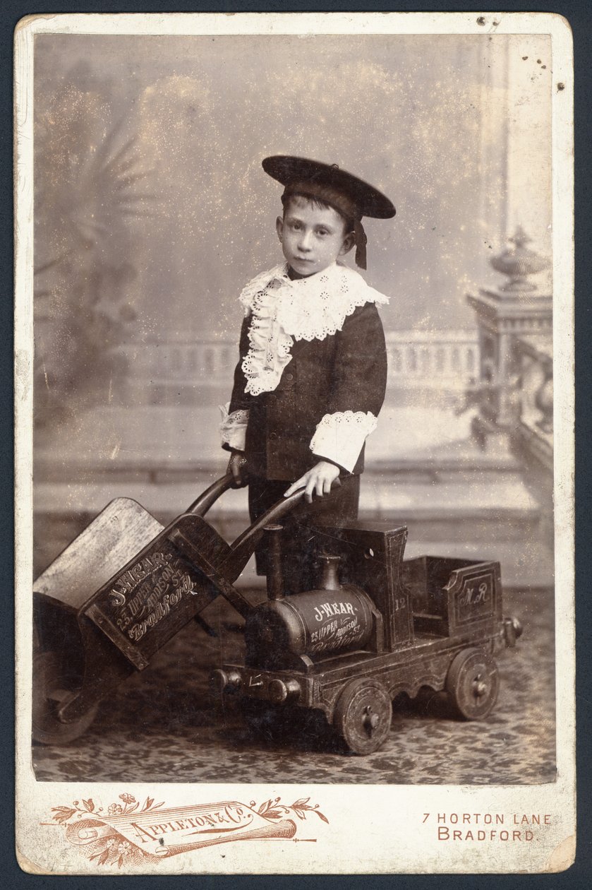 Niño con un tren de juguete y una carretilla de English Photographer