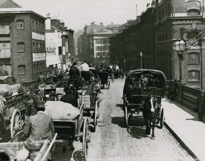 Carros tirados por caballos pasando sobre el Puente Southwark de English Photographer