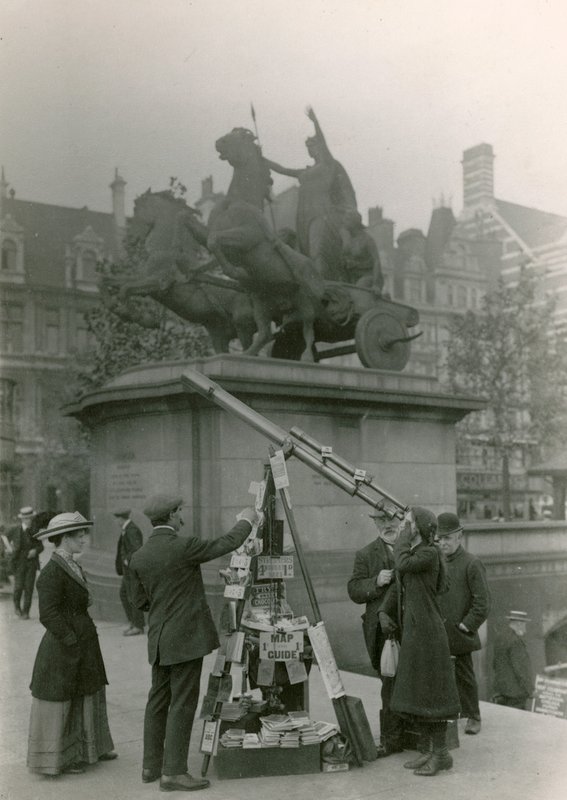 Un hombre vendiendo vistas a través de un telescopio de English Photographer