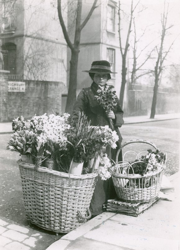 Una mujer vendedora de flores de English Photographer